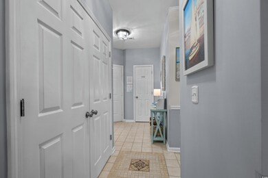 Hall featuring light tile patterned floors and baseboards