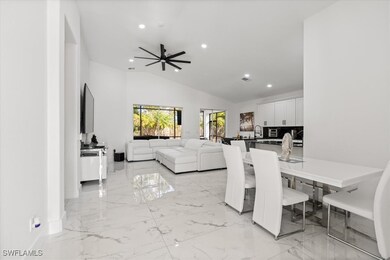 Dining room with ceiling fan, sink, and vaulted ce