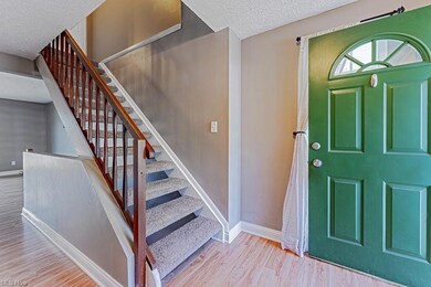 Hardwood floored entrance foyer with a textured ce