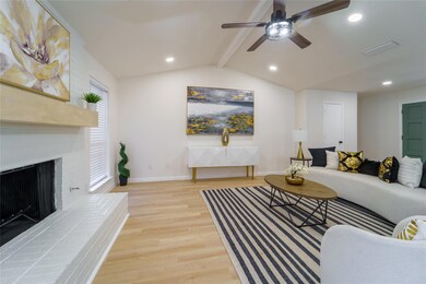 Living room featuring a brick fireplace, vaulted c
