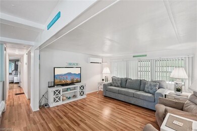 Living room featuring a wall mounted air conditioner and light wood-type flooring