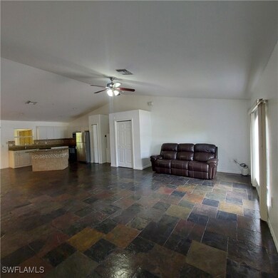 Living area featuring lofted ceiling, a ceiling fa