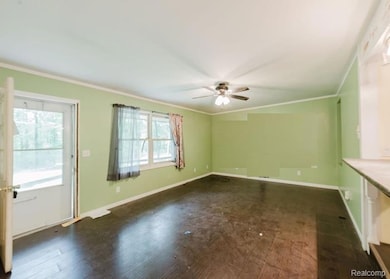 Unfurnished living room with ornamental molding, dark wood finished floors, and ceiling fan
