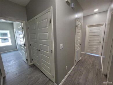 Hall featuring baseboards and dark wood-style flooring