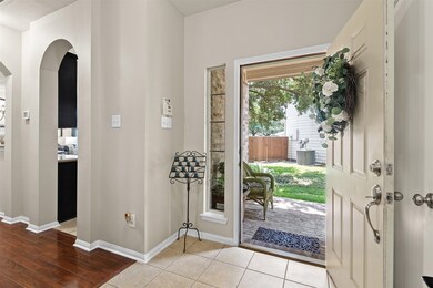 The front entry of the home has tile flooring and opens into the dining room.