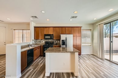 Kitchen with black appliances, luxury vinyl floors