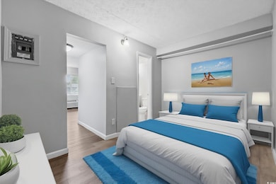 Bedroom featuring wood finished floors, baseboards, and connected bathroom