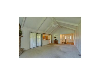 Great room w/ beamed ceilings opens to covered pat