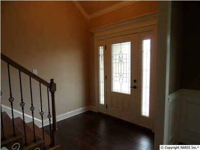 Foyer area with vaulted ceiling, hardwood floors, door with side lights on both sides, hardwood stairs on all steps.