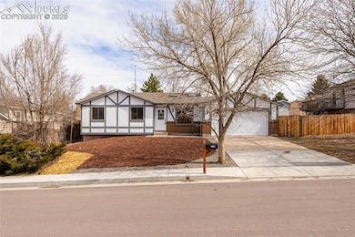 View of front of property featuring a garage, fenc