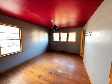 Living room featuring light wood-type flooring and a chandelier