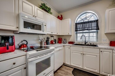 Kitchen featuring white appliances, crown molding,