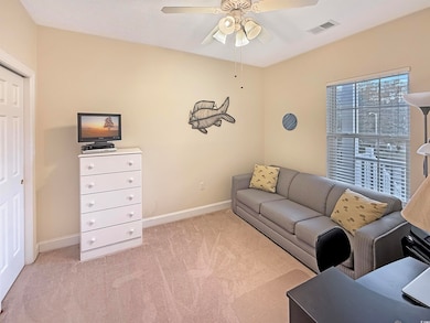 Carpeted living room with ceiling fan