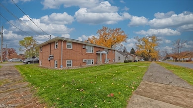 View of side of home featuring brick siding and a yard