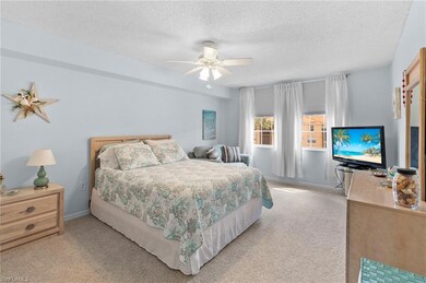 Carpeted bedroom with ceiling fan and a textured c