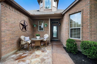 Property entrance featuring brick siding, a patio