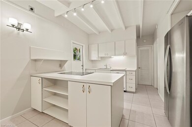 Kitchen featuring track lighting, light tile patte