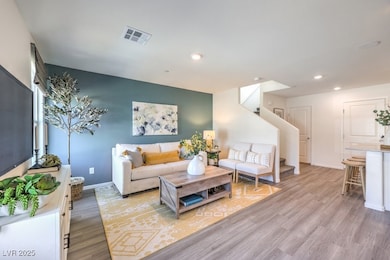 Living area with visible vents, light wood-style f