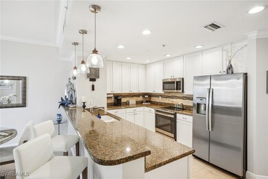 Kitchen featuring dark stone countertops, stainles