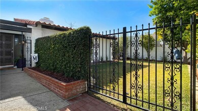 Approaching Front Door you see the Huge Private Front Yard behind Wrought Iron Gates with Lush Lawn and Front Porch