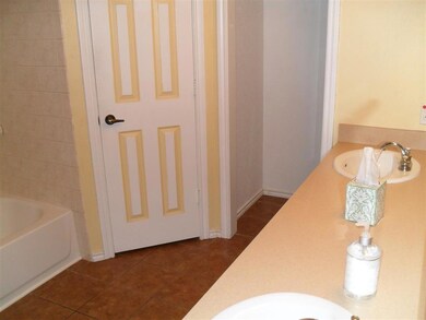 Bathroom with double vanity, a sink, and tile patt