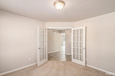 The den has ample lighting, French door entry and 