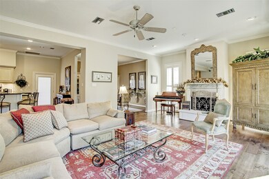 Beauty lives everywhere the eye falls. On the floor are beautiful engineered hardwood floors.  Above is crown moulding.  Ahead is a wood burning fireplace with a cast stone hearth and surround.