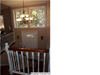 Foyer has lots of light, hardwood stairs and floor