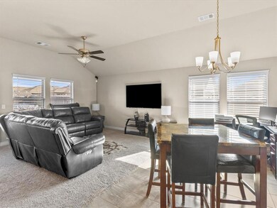 Dining room featuring lofted ceiling, ceiling fan with notable chandelier, and light tile patterned floors