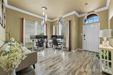 Foyer entrance featuring crown molding, light hard