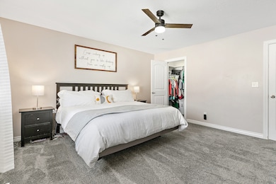 Spacious Primary suite with walk in closet, new carpet, ceiling fan and en suite bathroom /plenty of storage.