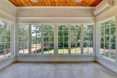 Unfurnished sunroom with tile patterned flooring, a wall unit AC, wood ceiling, plenty of natural light, and ornamental molding