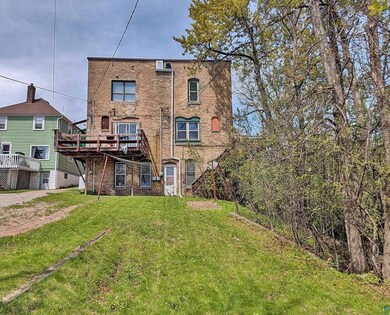 Rear view of house with a deck and a lawn