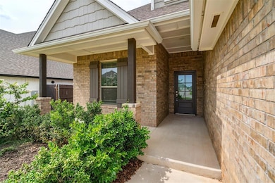 Doorway to property featuring brick siding, roof with shingles, and covered porch