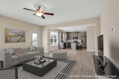 Living room with light wood finished floors, a ceiling fan, and recessed lighting