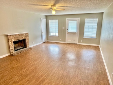 Unfurnished living room featuring a brick firepla