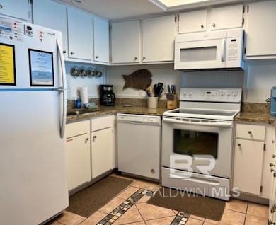Kitchen featuring white appliances and light tile patterned floors