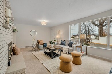 Carpeted living area with a fireplace and baseboards