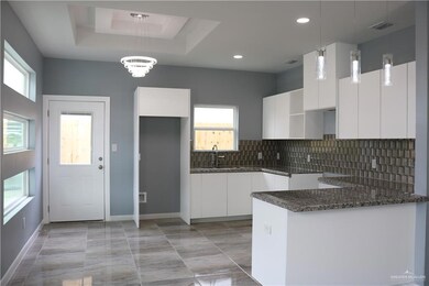 Kitchen featuring tasteful backsplash, decorative light fixtures, and plenty of natural light