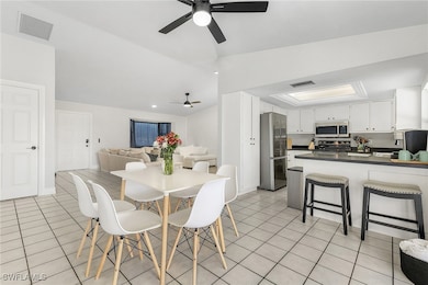 Dining space featuring a ceiling fan, vaulted ceil