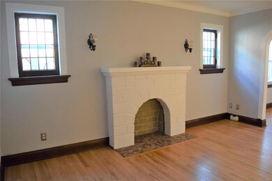 Decorative fireplace in living room flanked by sconces and stained glass windows