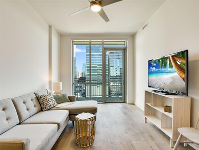 Living room featuring a ceiling fan and light woo