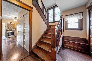 Stairway with a textured ceiling, dark hardwood fl