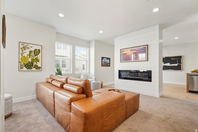 Living area featuring recessed lighting, light carpet, a fireplace, and a textured ceiling