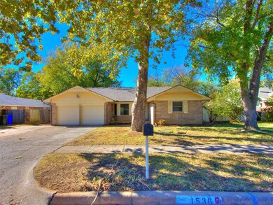 Ranch-style home featuring a front yard and a gara