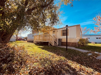 Rear view of property featuring a yard, a deck, and stairway