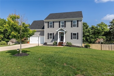 Colonial house with driveway, a shingled roof, and