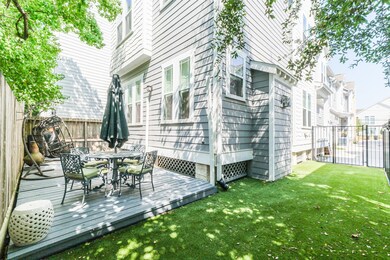 There is a gated side yard with turf and wood pati