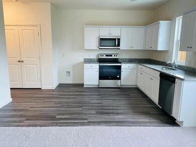 Kitchen with white cabinetry, dark hardwood / wood-style flooring, stainless steel appliances, and sink