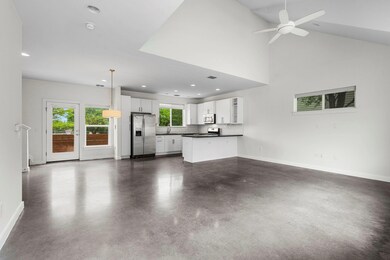 Unfurnished living room with a ceiling fan, concr